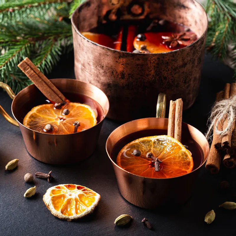 Mulled wine being served in copper mugs.