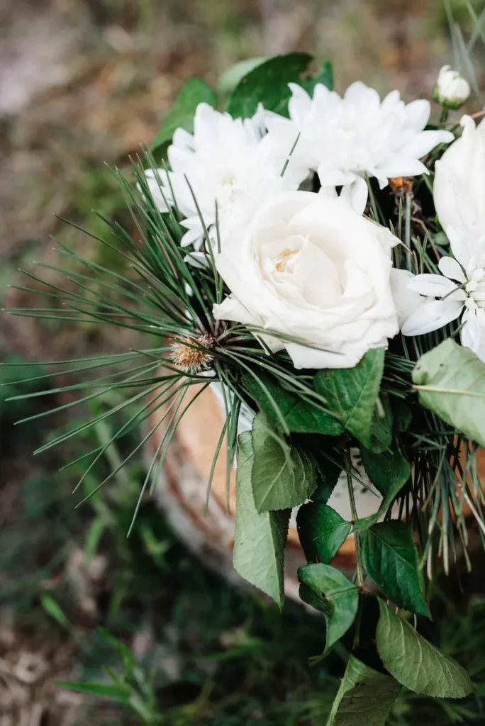 A bouquet or white roses and cedar.
