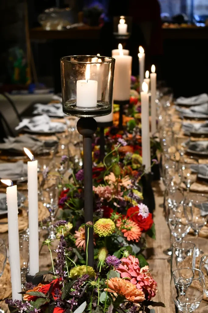 A long banquet table lit up by a bunch of lovely candles.