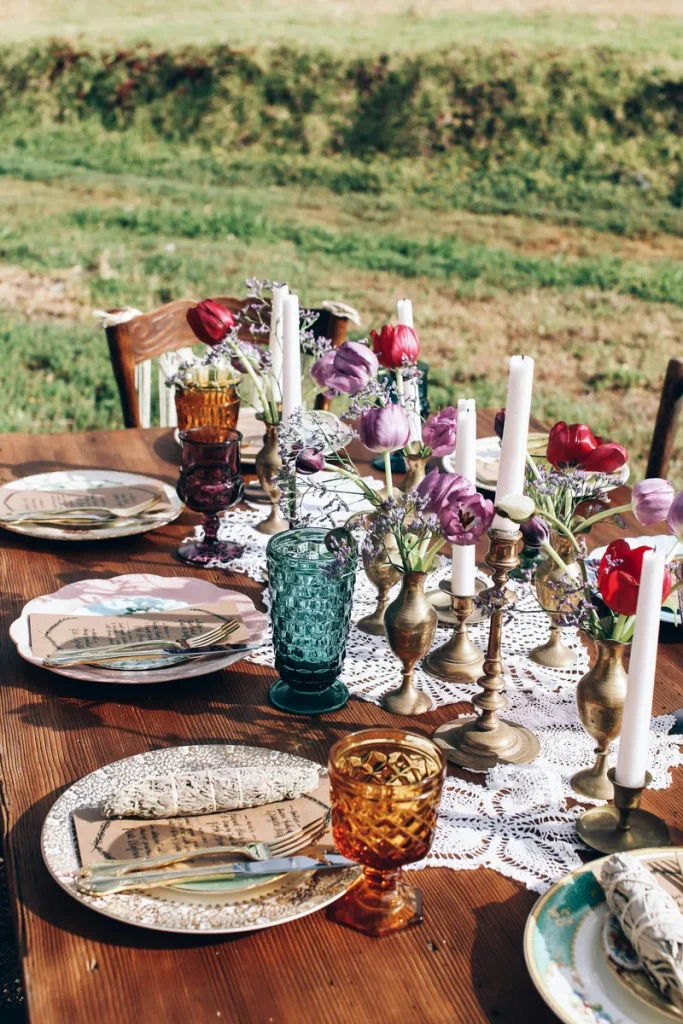 A boho tablescape with flowers and thrifted tableware. 