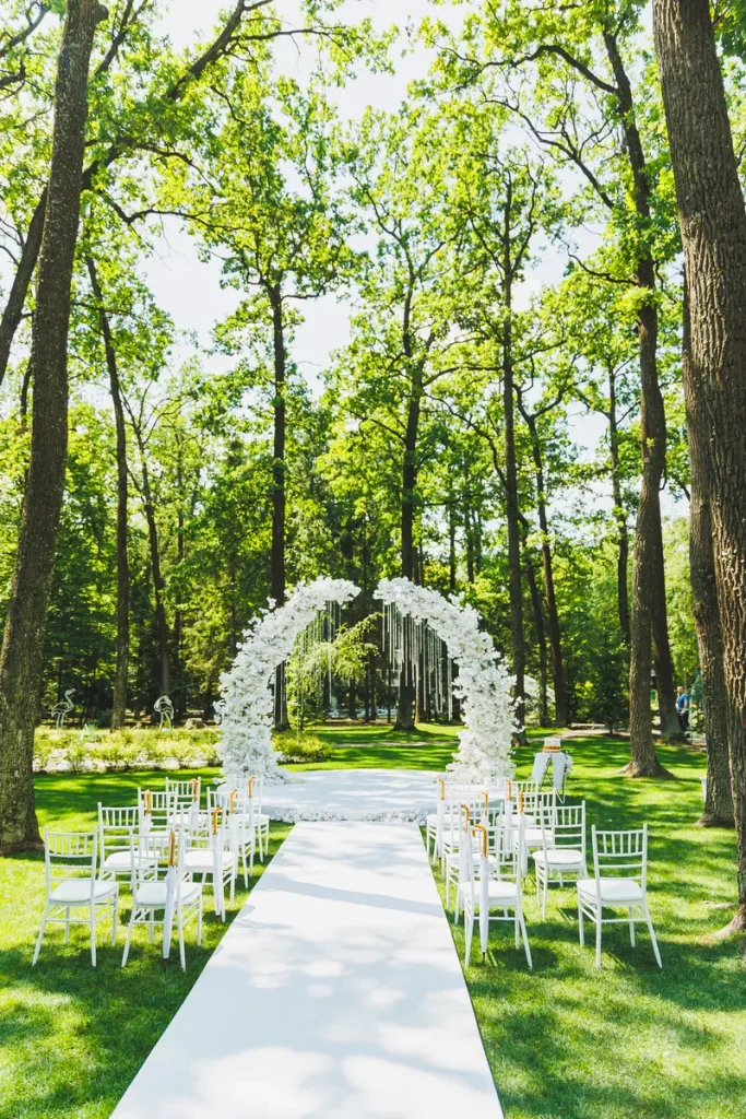 A picture of a white floral archway for a small garden ceremony.