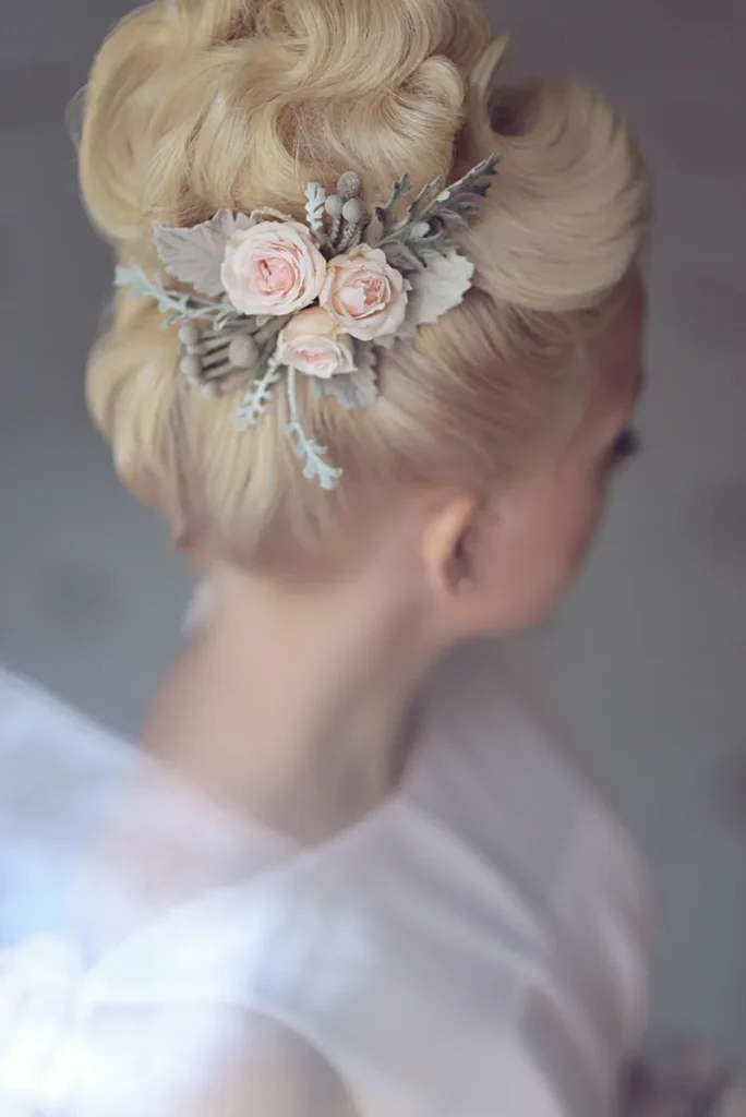 A curled updo with a floral accessory.
