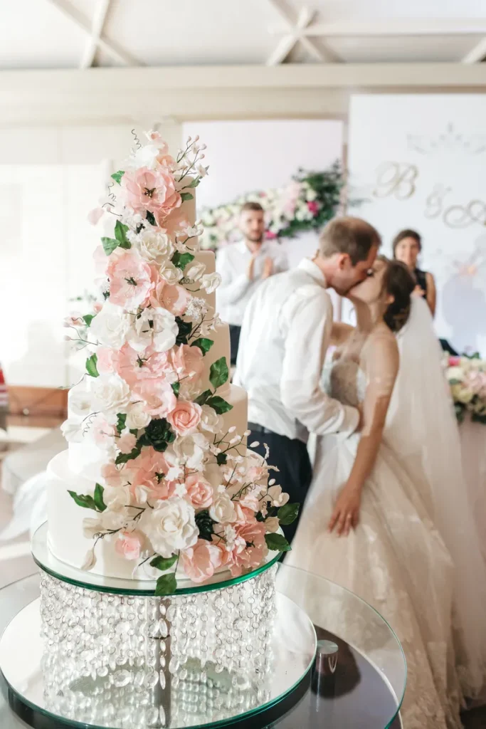 A beautiful tall wedding cake decorated with all kinds of flowers.