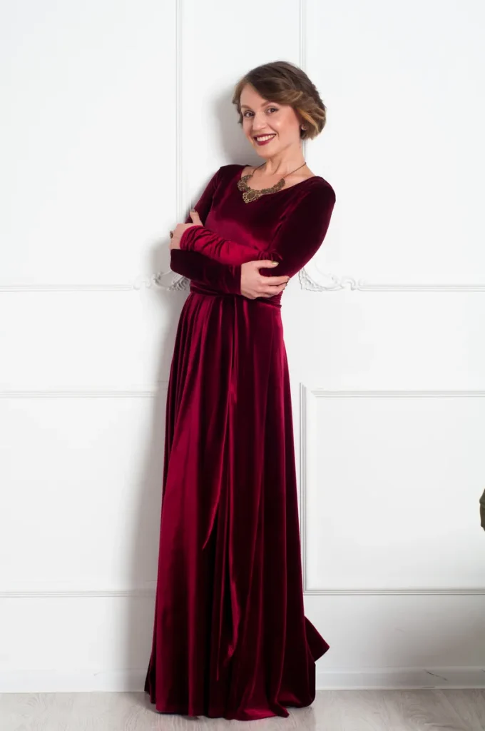 A wedding guest in a rich, red velvet dress.