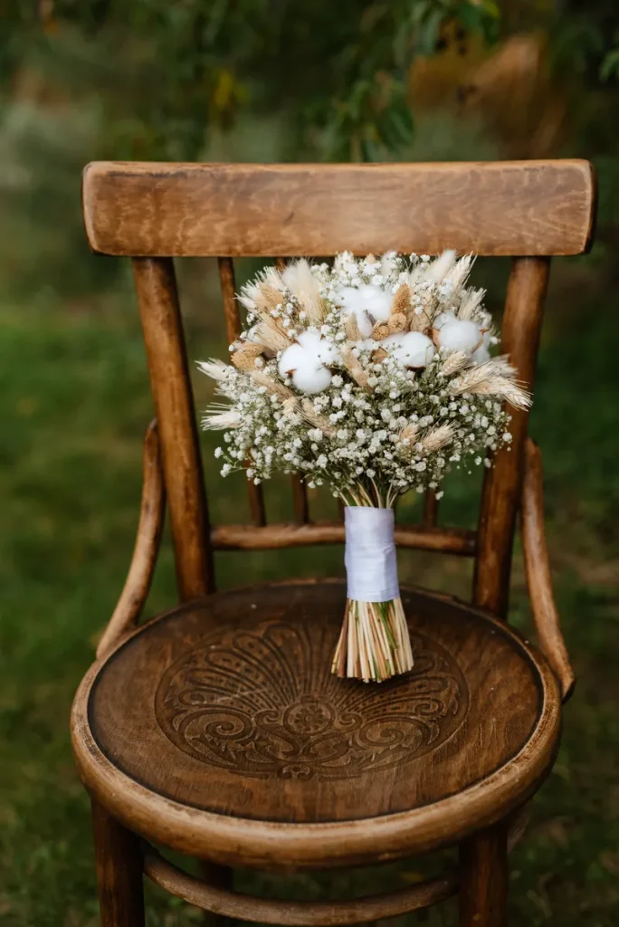 An old wooden chair with a bouquet on it.