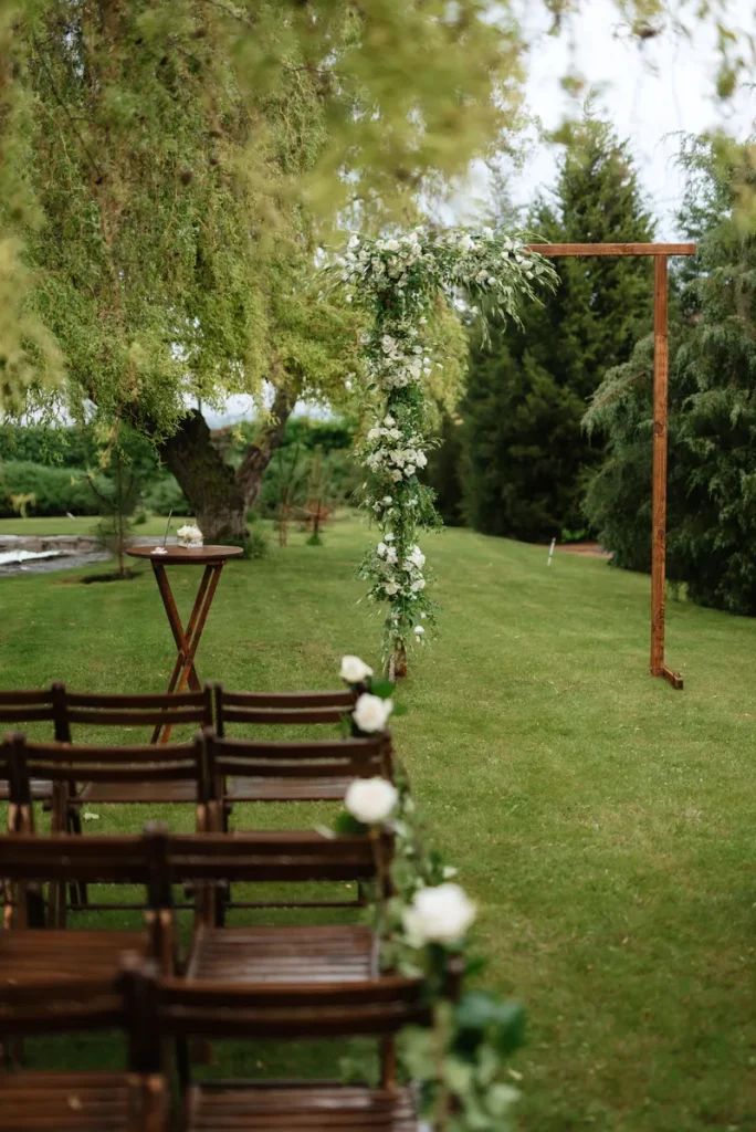 A simple wedding arch with one side covered in flowers.