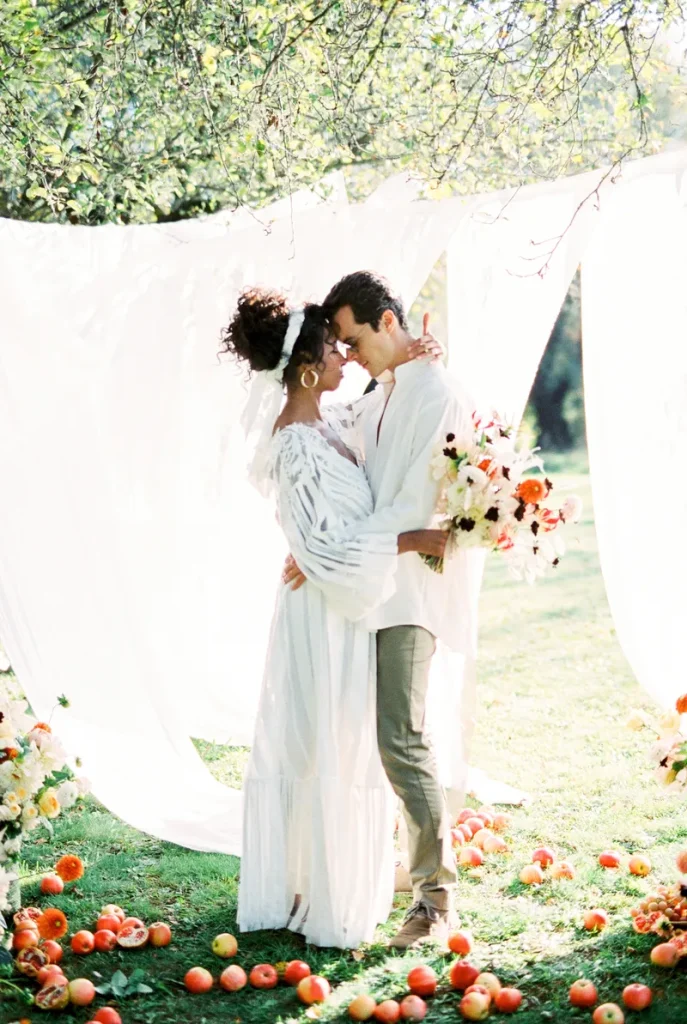 A couple in front of a fabric backdrop.