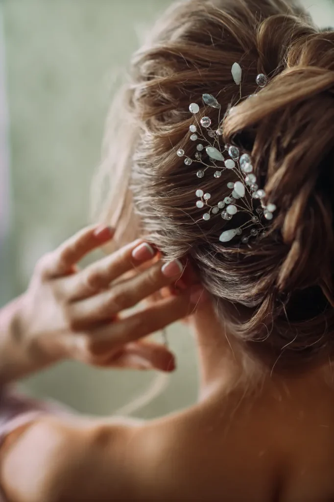 A low braided updo featuring a boho hair vine.