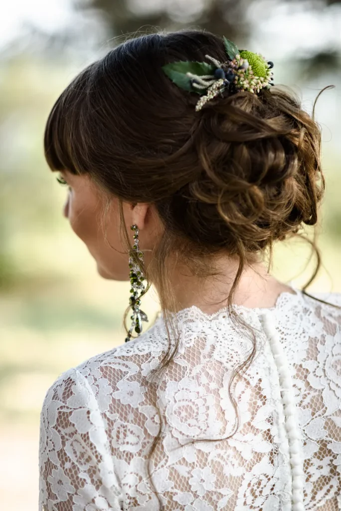 A boho wedding hair look that features a tastefully messy updo.