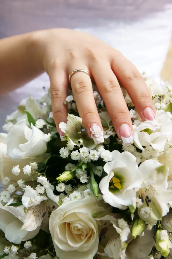 A simple french tip manicure with one sculpted flower as an accent nail.