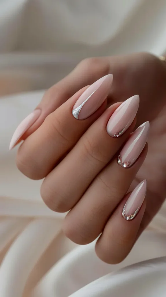 A classy rhinestone nail featuring just a few sparse stones on a soft blushy base.