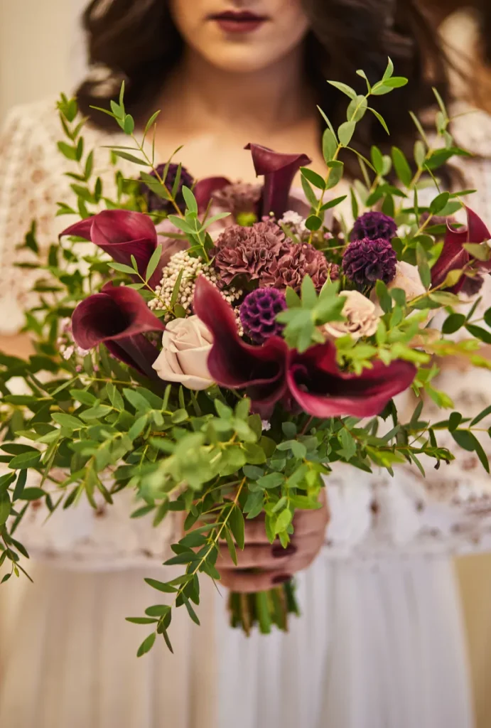 A look at a way to do a burgundy wedding bouquets, with the deeply colored flowers and some greenery with bits of paler flowers thrown in.