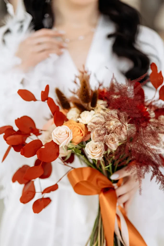 A burnt orange bridal bouquet option to look at, featuring burnt orange and paler orange flowers to set it off.