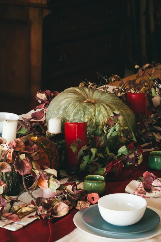 Rustic fall wedding centerpiece with a pumpkin and candles surrounding it.