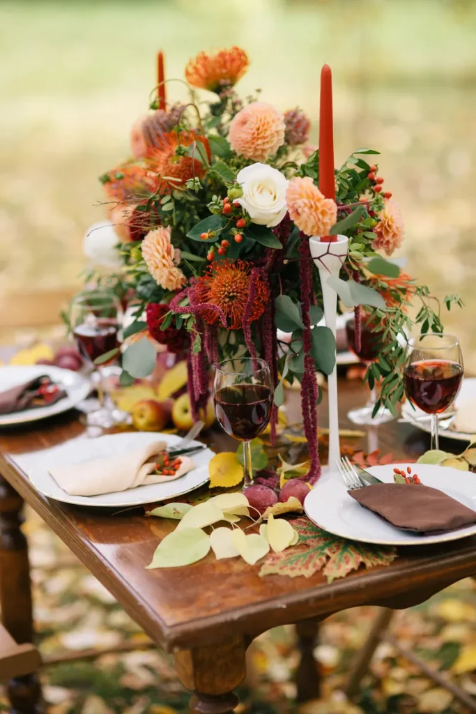 Elegant fall centerpiece ideas that still feel bright and cheerful, with deep reds and whites.
