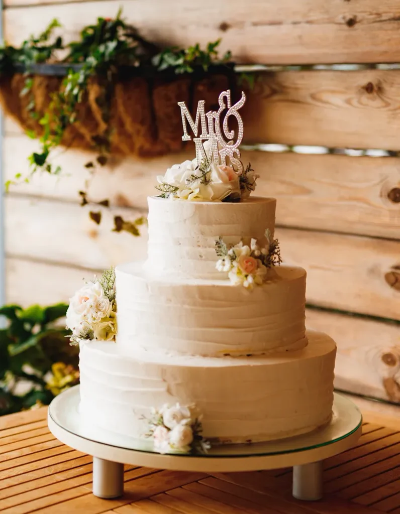 A simple bohemian cake featuring a little bit of buttercream texture and a few flowers.