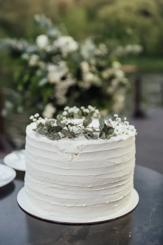 A small textured buttercream fall wedding cake featuring eucalyptus sprigs and baby's breath. 