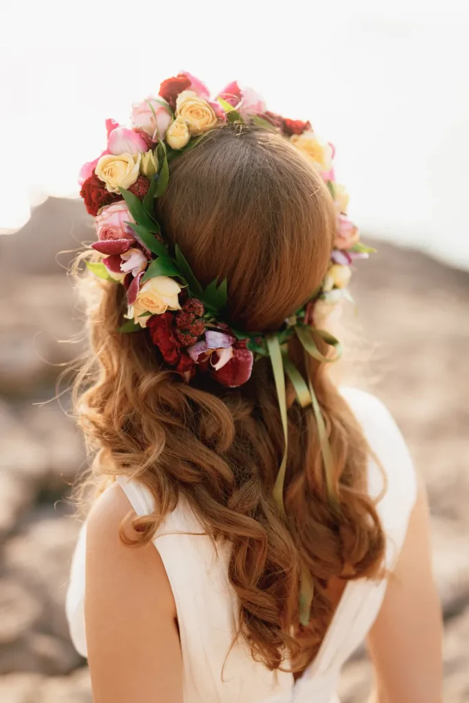 A beautiful flower crown with loose waves cascading down the brides back in this bohemian wedding hair look.