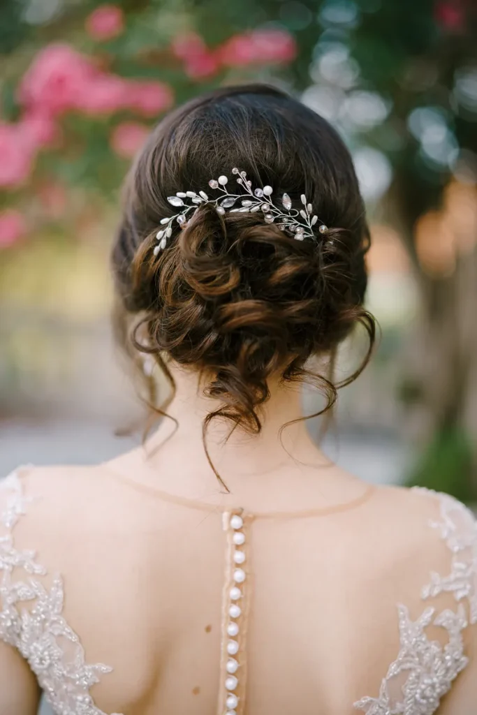 A hair vine delicately placed in a low bun in this bohemian wedding hair.