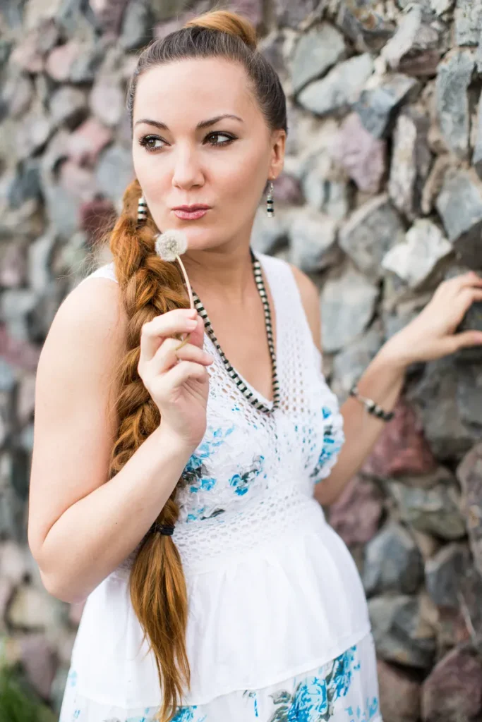 A lovely look at bohemian wedding hair that consists of a loos side braid and a high pony.