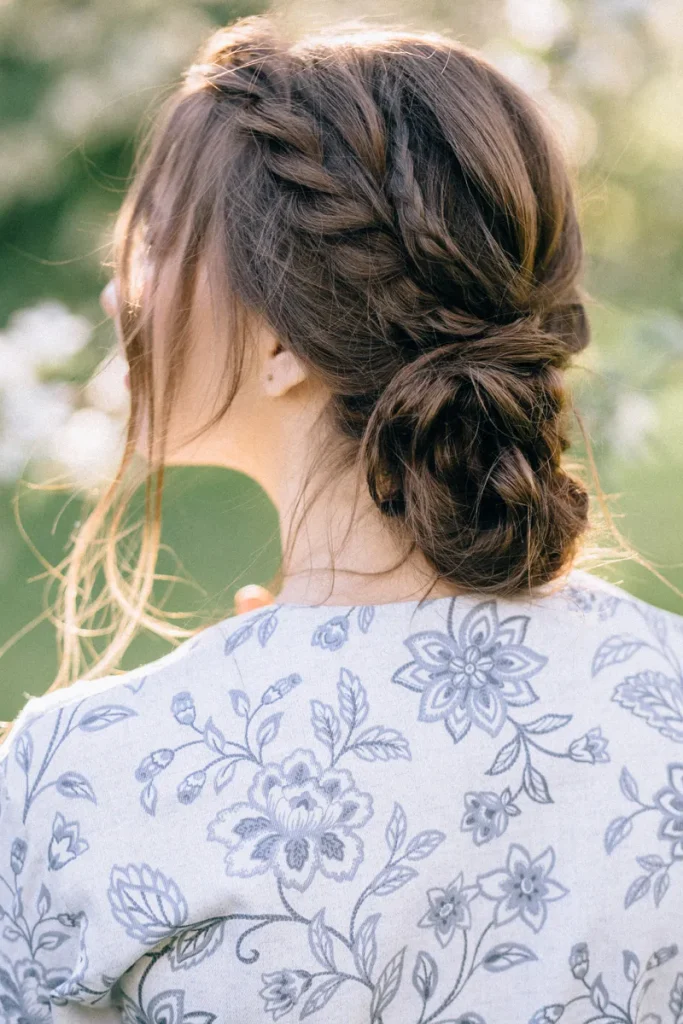 A low textured bun with braids going into it that you could use for your bohemian wedding hair.