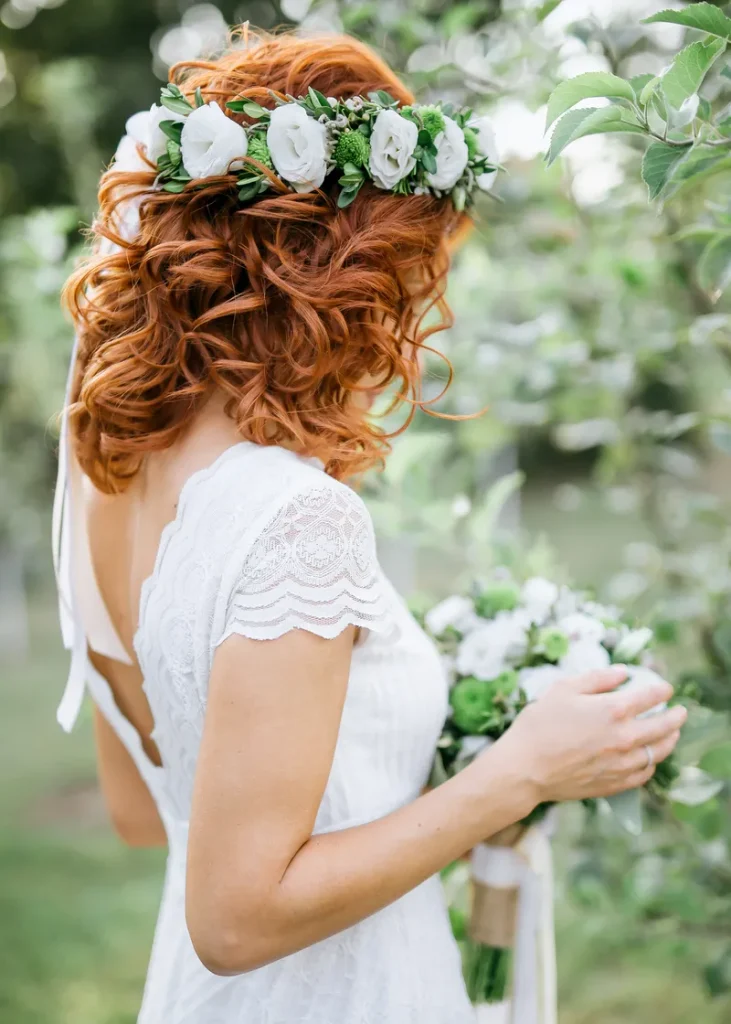 A short bohemian wedding hair look with a flower crown and loose curls.