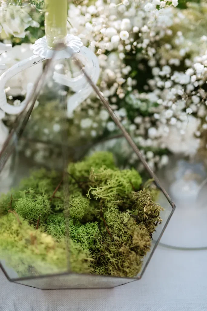 A fall wedding centerpiece featuring a woodland theme and some moss.